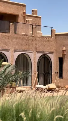 a brick building with windows and a table in front of it at Villa Beij in Marrakech