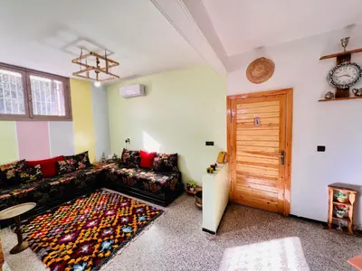 a living room with a couch and a wooden door at spacious apartment with terrace in Fès