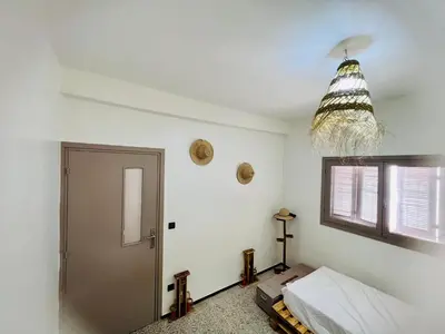 a room with a bed and a door and a window at spacious apartment with terrace in Fès