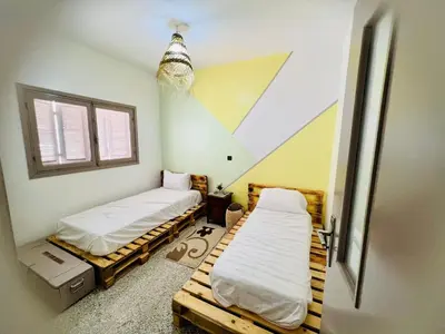an attic room with two beds and a window at spacious apartment with terrace in Fès
