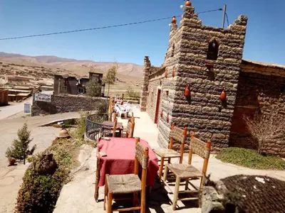 a table and chairs in front of a stone building at Auberge Amazigh in Tamtetoucht