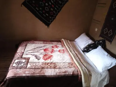 a bedroom with a bed with a blanket on it at Auberge Amazigh in Tamtetoucht
