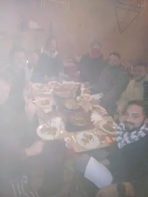 a group of people sitting around a table eating food at Auberge Amazigh in Tamtetoucht