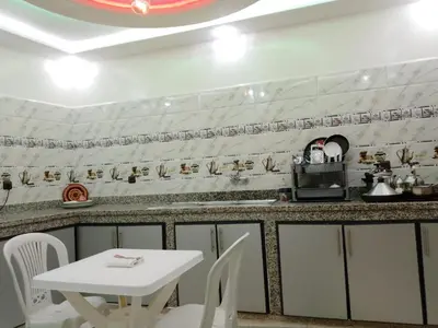 a kitchen with a white table and white chairs at DIAAFATE TANNIRTE in Khenifra
