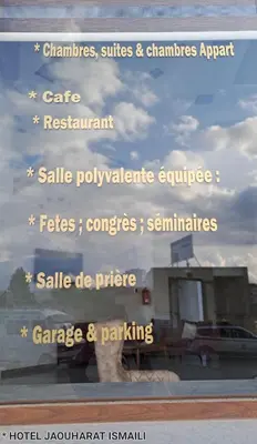 a sign in a window that reads pharmacies suites and pharmaciesagent cafe restaurant sale at Hotel Jaouharat Ismaili in Meknès