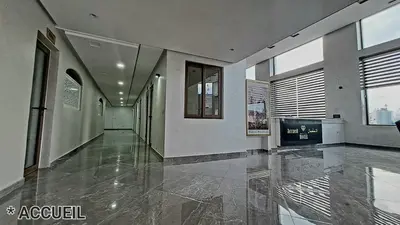an empty hallway with a large room with windows at Hotel Jaouharat Ismaili in Meknès
