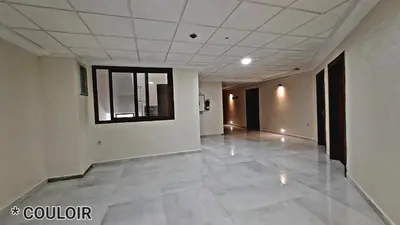 an empty hallway with a tile floor and a window at Hotel Jaouharat Ismaili in Meknès