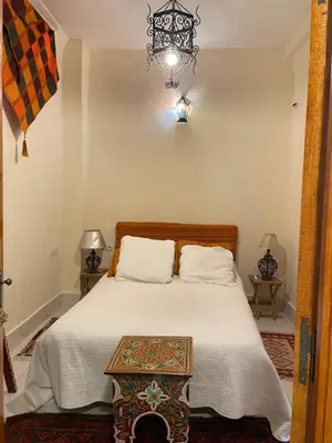 a bedroom with a bed and a chandelier at DAR ALKATIB MEKNES in Meknès
