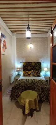 a bedroom with a bed and a table in it at DAR ALKATIB MEKNES in Meknès