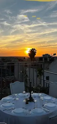 a table on a balcony with the sunset in the background at DAR ALKATIB MEKNES in Meknès