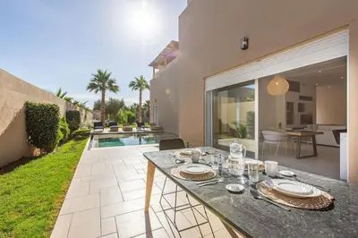 a table with plates on it in a backyard at Villa Safiya, luxe et détente, jeux, cuisinière in Marrakech