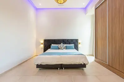 a bedroom with a bed with a black headboard at Villa Safiya, luxe et détente, jeux, cuisinière in Marrakech