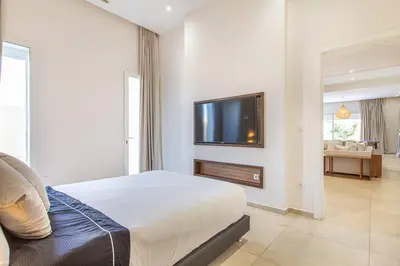 a bedroom with a bed and a flat screen tv at Villa Safiya, luxe et détente, jeux, cuisinière in Marrakech