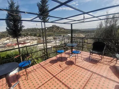 a patio with chairs and tables on a balcony at Studio avec piscine et parking prive in Fès