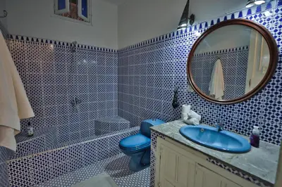 a bathroom with a blue toilet and a mirror at Studio avec piscine et parking prive in Fès