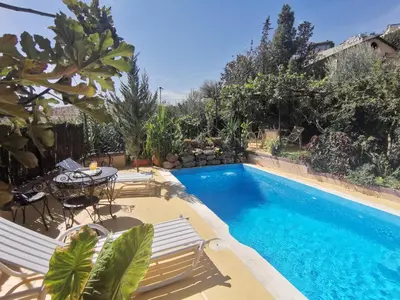 a swimming pool with chairs and a table next to it at Studio avec piscine et parking prive in Fès