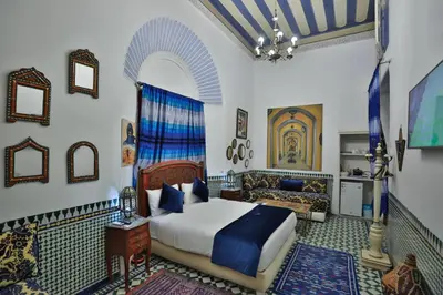 a bedroom with a bed and a couch at Studio avec piscine et parking prive in Fès