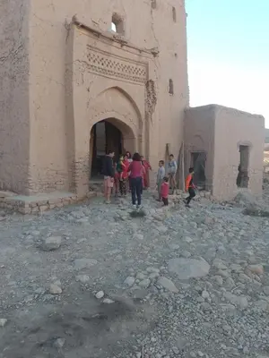 a group of people standing outside of a building at gîte d'étape ziz oasis in Achbarou
