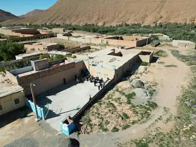 a group of people standing in front of a building at gîte d'étape ziz oasis in Achbarou