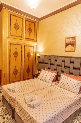 two beds in a hotel room with towels on them at HOTEL LA VALLEE DES KASBAHS CHEZ ILYAS in Tinerhir