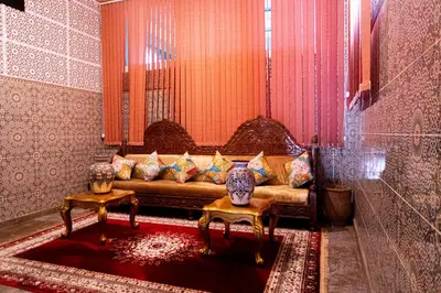 a living room with a couch and two tables at HOTEL LA VALLEE DES KASBAHS CHEZ ILYAS in Tinerhir