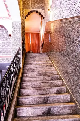 a set of stairs in a building with a wooden door at HOTEL LA VALLEE DES KASBAHS CHEZ ILYAS in Tinerhir