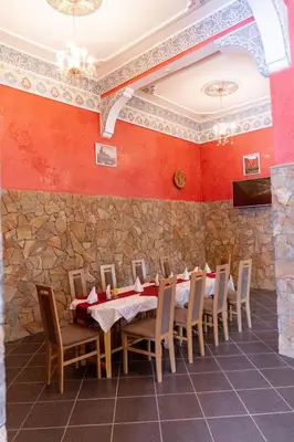 a dining room with red walls and a table and chairs at HOTEL LA VALLEE DES KASBAHS CHEZ ILYAS in Tinerhir