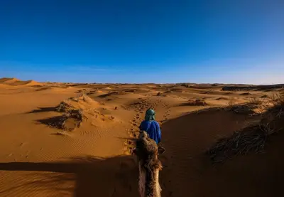a person walking through the desert at Sinbad luxury camp in Merzouga
