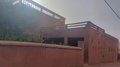 a large brick building with a ramp in front of it at Dar badiawarda in Azilal