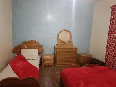a room with two beds and a basket and a table at Dar badiawarda in Azilal