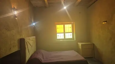 a small bedroom with a bed and a window at Dar badiawarda in Azilal