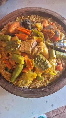 a bowl of food with meat and vegetables on a table at Dar badiawarda in Azilal