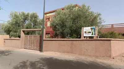 a gate with a sign in front of a building at Dar badiawarda in Azilal