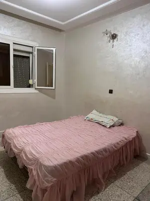 a bedroom with a bed with a pink blanket on it at NADIA BELVUE 3 in Meknès