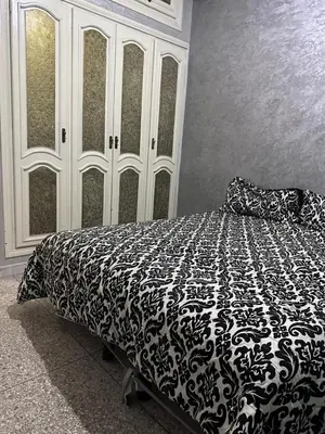 a bedroom with a bed with a black and white blanket at NADIA BELVUE 3 in Meknès