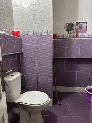 a bathroom with a toilet and purple tiled walls at NADIA BELVUE 3 in Meknès
