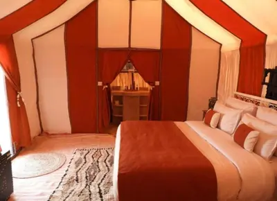 a bedroom with a large bed in a room at Desert Paradise Luxury Camp in Merzouga