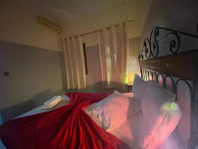 a bedroom with a bed with a red blanket at APPART AIGLE HOTEL in Ouarzazate