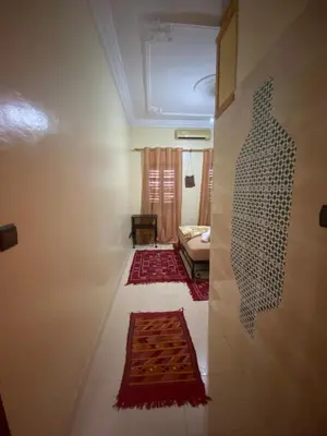 a living room with a couch and a rug on the floor at APPART AIGLE HOTEL in Ouarzazate