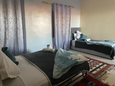 a living room with two beds and a window at APPART AIGLE HOTEL in Ouarzazate