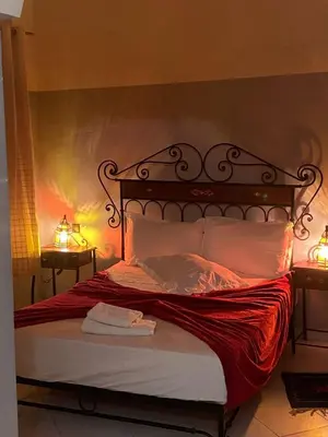 a bedroom with a bed with two lights on it at APPART AIGLE HOTEL in Ouarzazate
