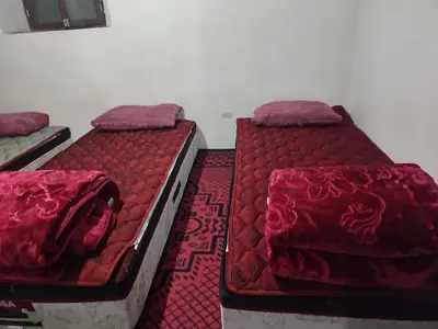 two beds sitting next to each other in a room at Houcine gite in Taza