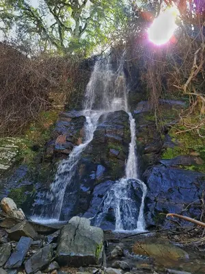 a waterfall on the side of a rock formation at Houcine gite in Taza
