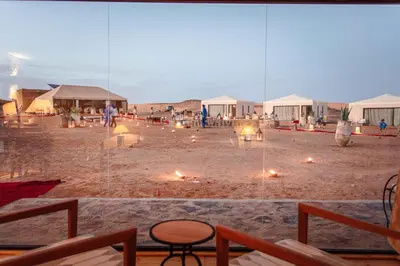 a group of tents in the desert with candles at Merzouga luxury desert camps in Merzouga