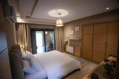 a bedroom with a white bed and a dresser at Riad Bella Montana in Fès