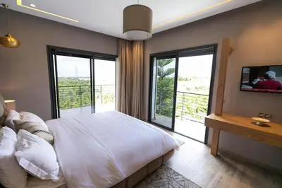 a bedroom with a white bed and a balcony at Riad Bella Montana in Fès