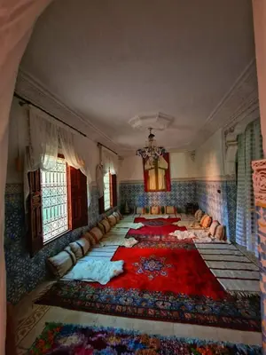 a large room with a large red rug on the floor at Villa DALIA - artistic and Cultural Residence in Aghmat