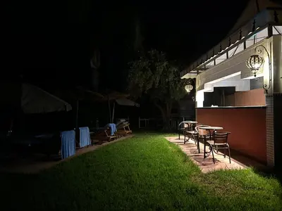 a backyard with tables and chairs at night at Villa DALIA - artistic and Cultural Residence in Aghmat