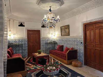 a living room with red furniture and a chandelier at Villa DALIA - artistic and Cultural Residence in Aghmat