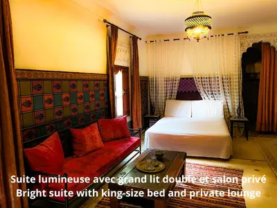 a hotel room with a bed and a couch at Villa DALIA - artistic and Cultural Residence in Aghmat